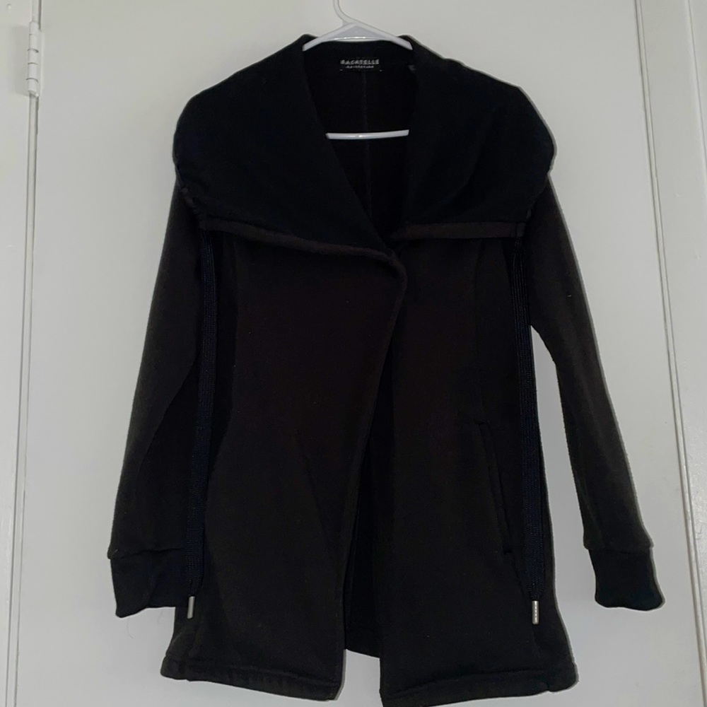 black sweater, with a cross on the neck as closure, long